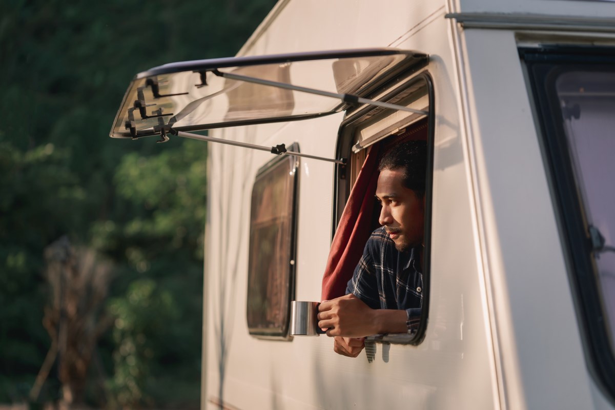 Young man looking out of RV window.