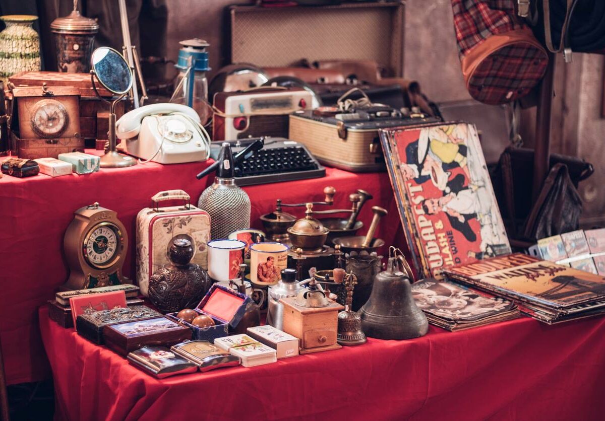 A collection of vintage items arranged on a table at a flea market.