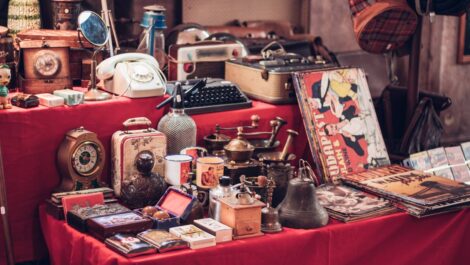 A collection of vintage items arranged on a table at a flea market.