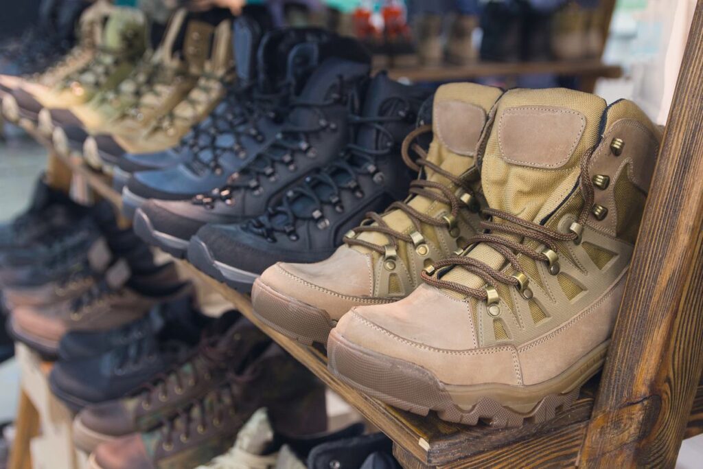 A close-up of hunting boots lined up on a rack.