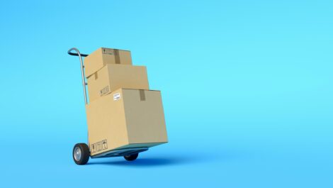 A dolly carting three cardboard boxes on a blue background