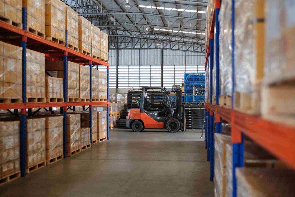 Modern warehouse of auto parts factory with forklift trucks parked near shelves 