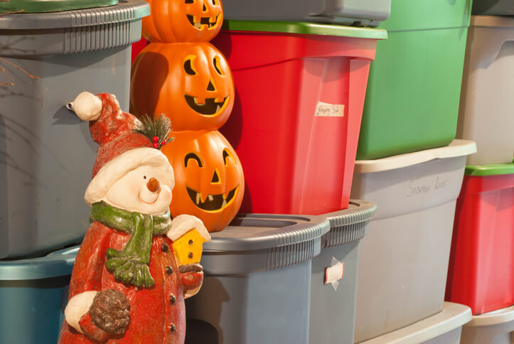 Seasonal belongings and plastic bins, including a snowman and pumpkins.