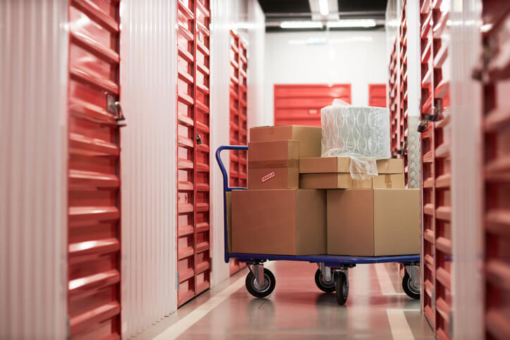 A cart with cardboard boxes sits in the hallway of an indoor storage facility.