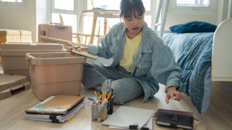 A young woman going over her checklist for dorm essentials as she prepares to move into the dorms.