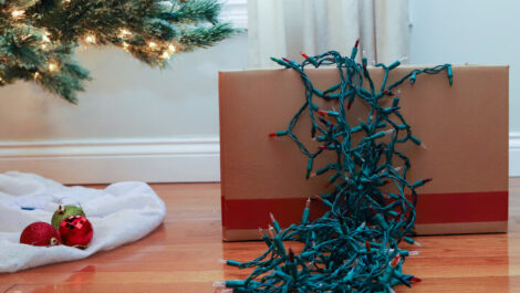 A strand of Christmas lights cascading out of a sturdy cardboard box.