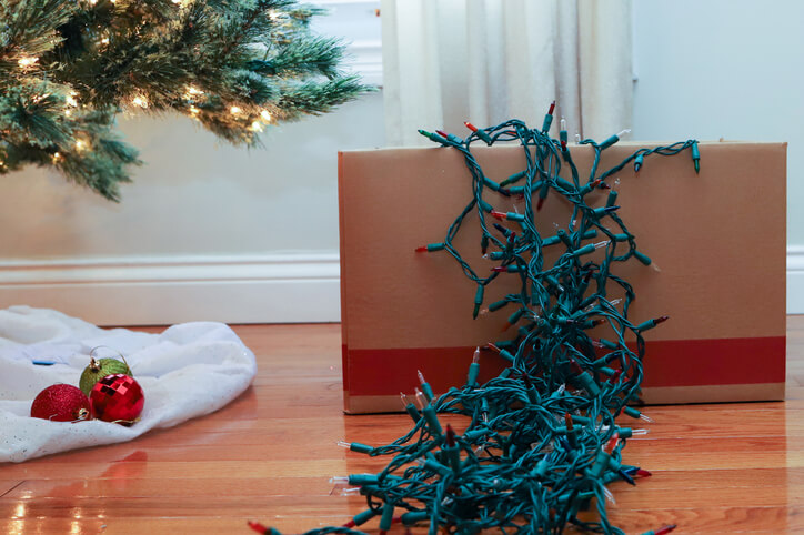 A strand of Christmas lights cascading out of a sturdy cardboard box.