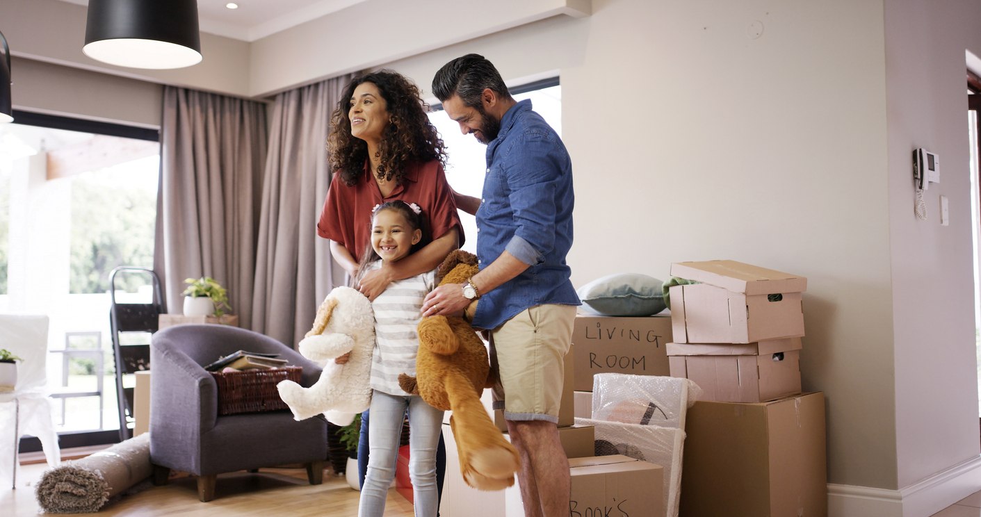 A smiling family with storage boxes in their home.