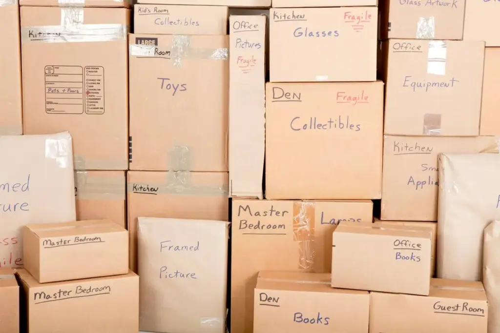 Large stack of labeled cardboard moving boxes organized by room.